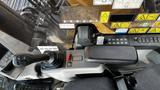 View of the control panel inside a 2018 Caterpillar 326F L Excavator showing the joystick controls and various operational buttons and warning labels