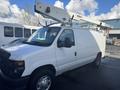 A white 2008 Ford Econoline van with a mounted Versalift aerial work platform on its roof