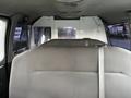 Interior view of a 2011 Ford Econoline showing the back seat and a partition separating the front from the cargo area