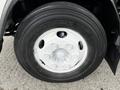 Close-up of a white wheel on a 2022 Isuzu NPR featuring a five-bolt pattern and a black Duravis tire with visible tread and brand markings