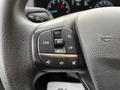 Close-up of the steering wheel controls of a 2020 Ford Transit featuring buttons for cruise control and audio settings