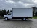 A white 2019 Ford Econoline box truck with a large empty cargo area and dual rear wheels parked on a paved surface