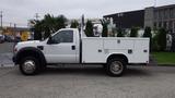 A white 2008 Ford F-450 SD truck with a utility bed and chrome wheels parked on a concrete surface