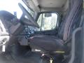 A 2005 Freightliner M2 106 Medium Duty truck interior featuring a driver's seat with striped fabric and a dashboard with various controls and instruments