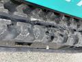 Close-up of the tread on a 2024 AGT Industrial Green QH13R Mini Excavator showing wear and tear on the tracks