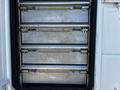 The image shows the open storage compartments of a 2004 Freightliner M2 featuring four stacked metal drawers with handles