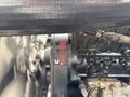 Close-up of a 1998 Freightliner FL80 engine with visible components including an alternator and various hoses and connections