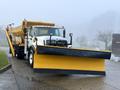 A 2016 International 7400 snow plow truck equipped with a yellow plow at the front and a salt spreader in the back