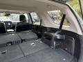 Interior of a 2021 Toyota 4Runner with the rear seats folded down creating a flat cargo area featuring gray carpeting and seatbelt clasps visible