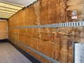 Interior view of a 2015 Freightliner M2 106 truck with wooden walls and metal track systems for securing cargo