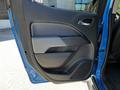 The image shows the interior driver's side door panel of a 2021 Chevrolet Colorado featuring a sleek design with controls and door handle