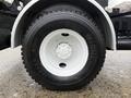 A close-up of a black Michelin tire mounted on a white steel rim specifically designed for a 2016 Freightliner 108SD truck