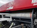 A 2020 Pottinger Impress machine featuring a large roller covered in twine with visible safety labels and warning signs