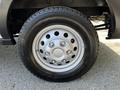 A close-up of a silver wheel with a five-bolt pattern and a black tire featuring tread designed for traction and durability