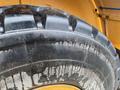 A close-up of a large tire from a 2016 Hyundai HL940 heavy machinery vehicle showing deep treads and a worn surface