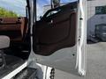 A 2021 Hino 338 truck door is open showing the interior handle and armrest in brown color with a textured surface and a gray seat visible inside