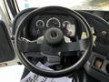 The steering wheel and dashboard of a 2012 Autocar Xpert showing gauges and controls