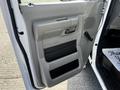 The image shows the driver's side door panel of a 2019 Ford Econoline featuring a handle a control knob and multiple storage compartments