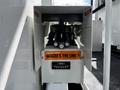 A control panel of a 2012 Freightliner M2 106 featuring dials and levers with a warning sticker about power line safety