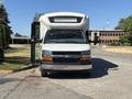 A 2017 Chevrolet Express with a white body and black front grille is parked facing forward with the side door open