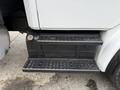 A black perforated step leading up to the cab of a white 1998 Freightliner FL80 truck