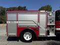 A red 1991 International 4600 fire truck featuring silver storage compartments and a prominent emergency light on top