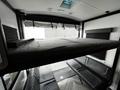 Interior view of a 2022 Heartland Torque with a lower sitting area and an upper bunk bed that can be retracted or lowered as needed
