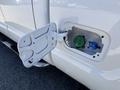 A white 2014 Ford F-250 SD with an open fuel door displaying a green and blue fuel cap inside