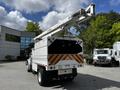 A 2012 Freightliner M2 106 truck equipped with a raised aerial bucket and a storage compartment at the rear