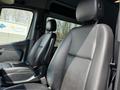 Front seats of a 2019 Mercedes-Benz Sprinter showing black leather upholstery and a clean, minimalist design