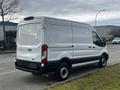 A white 2020 Ford Transit van parked on a street with a plain rear view and no visible company logos or markings