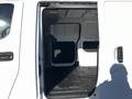 Interior view of a 2017 Nissan NV200 with open sliding side door showing a spacious cargo area and dark flooring