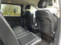 Interior view of a 2018 Mercedes-Benz Metris showing black leather seats with a spacious layout and a central console between the front seats