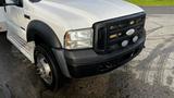 A 2007 Ford F-550 with a white exterior and black front grille featuring round lights and a chrome emblem