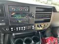 Dashboard of a 2017 Chevrolet Express featuring gauges controls and buttons for audio and climate settings with a cup holder below