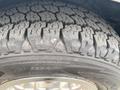 Close-up of a heavily treaded tire on a 2014 Chevrolet Express showing detailed tire patterns and robust surface suitable for all-terrain driving