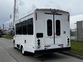A white 2016 Ford Econoline with multiple windows and a rear entry ramp for accessibility