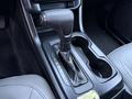 The gear shift of a 2019 Chevrolet Colorado with a leather-wrapped knob and a console featuring gear position indicator and cup holders