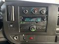The dashboard of a 2017 Chevrolet Express featuring a radio display with tuned frequency FM 100.7 and various buttons for controls