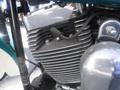 Close-up of the engine of a 2009 Harley-Davidson FLSTC featuring a silver cylinder head with horizontal fins and a chrome cover displaying hoses and bolts