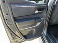The interior door panel of a 2023 Toyota Tundra featuring a textured surface and a sleek handle with a built-in speaker area