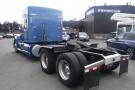 A blue 2015 Kenworth T660 truck with a prominent cab and large rear tires parked with its chassis visible and no trailer attached