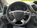 A 2018 Ford Transit steering wheel with a central Ford logo and various control buttons on the spokes