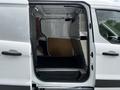 A 2014 Ford Transit Connect van with an open rear door revealing a spacious cargo area with a rubber floor and metal lining