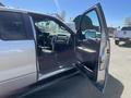 A 2014 Ford F-150 with an open front door showing the interior and driver’s seat