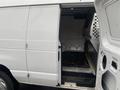 A white 2011 Ford Econoline van with an open side door revealing the cargo area and metal flooring