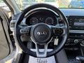 Interior view of a 2018 Kia Rio5 with a steering wheel featuring controls and a dashboard displaying gauges and an infotainment screen