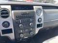The image shows the interior dashboard of a 2012 Ford F-150 featuring the audio system controls and air conditioning settings