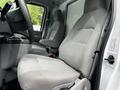 Interior of a 2021 Ford E-450 showing two gray fabric seats with armrests and a steering wheel visible on the left side