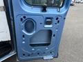 A blue 2010 Ford Econoline door panel with cutouts and no handle visible